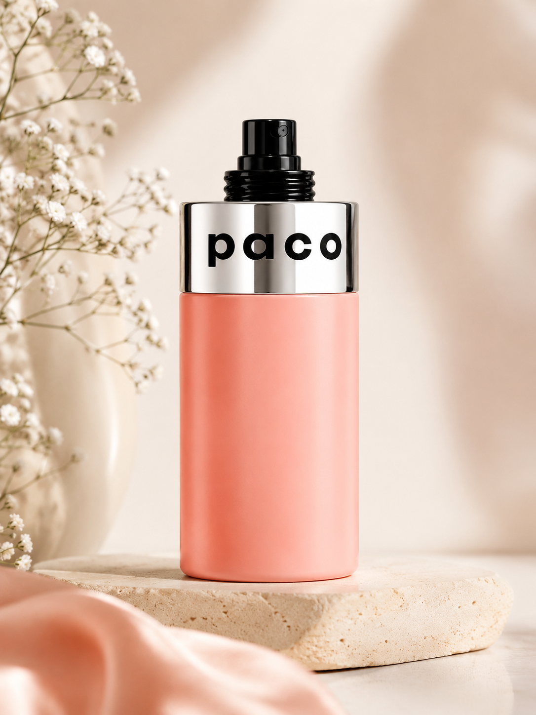 Paco by Paco Rabanne showcased in a clean, elegant setting that highlights its iconic minimalist design. The soft blush-pink bottle paired with polished metallic accents reflects a fresh, modern, and youthful fragrance character, combining simplicity with timeless style.