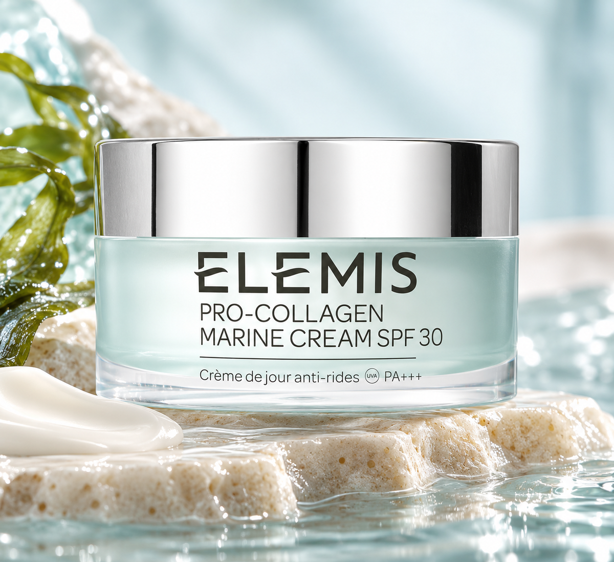 ELEMIS Pro-Collagen Marine Cream SPF 30 in an elegant pale blue jar with a reflective silver lid, beautifully displayed on natural stone beside fresh green leaves, flowing water and a silky cream texture. Luxurious anti-aging day cream with SPF 30 UVA and UVB protection, designed to hydrate skin and reduce the appearance of fine lines and wrinkles.