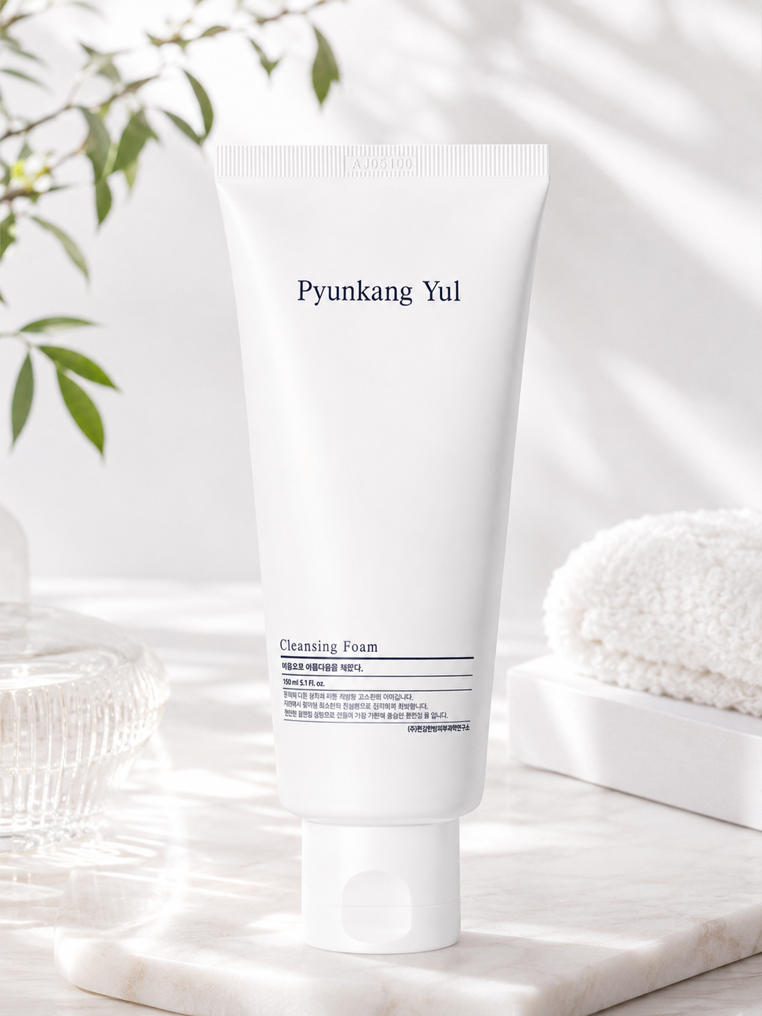 Pyunkang Yul Cleansing Foam 150ml tube on a white background with green leaves.